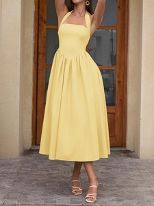 Detail of bright yellow halter neck midi dress with V-shaped pleats and A-line skirt