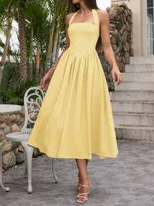 Detail of light yellow halter midi dress showing V-shaped waist and pleated A-line skirt