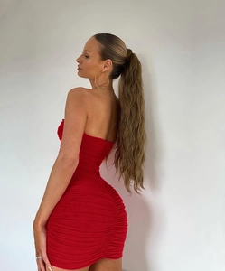 Detail of red ruched bodycon mini dress showing side view of pleated stretch fabric