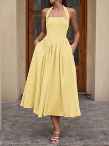 Detail of light yellow halter dress featuring high waist pleats and functional pockets