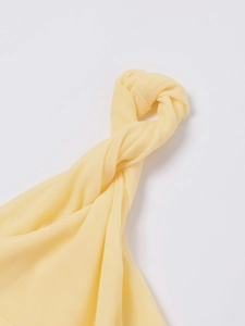 Détail du nœud torsadé sur le tissu en maille crème de cette robe d'été ajustée sexy