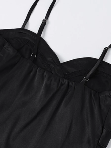 Detailed view of black satin dress with adjustable spaghetti straps and sweetheart neckline