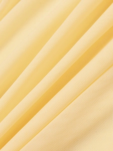 Vue macro détaillée du tissu en maille jaune crème avec texture plissée respirante