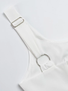 Detail eines weißen Kleid-Schultergurts mit silberner Schnalle und rundem Metallring