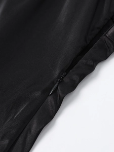 Detailed macro view of the invisible zipper on a smooth black satin dress