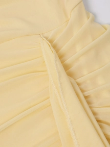 Détail du tissu en maille jaune clair avec plis délicats et couture surjetée professionnelle