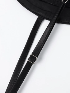 Detail of adjustable spaghetti straps and silver buckles on a black satin dress