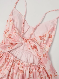 Détail d'une robe fleurie rose avec un design croisé au dos et des bretelles réglables