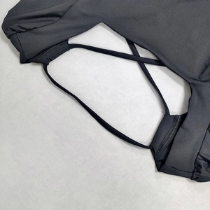 Dettaglio di un vestito nero con spalline incrociate e cuciture precise del tessuto