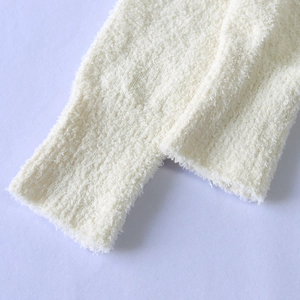Detail of white plush coral fleece robe showing thick ribbed cuffs and soft texture