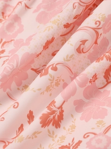 Détail du tissu à imprimé fleuri avec feuilles oranges et fleurs roses sur robe à col V