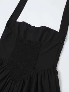 Detail view of the smocked elastic back and invisible zipper on this black halter dress