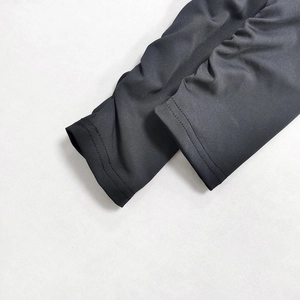Dettaglio del tessuto grigio scuro elasticizzato con maglia fine e cuciture a doppio ago