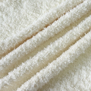 Close-up of cream-white thick teddy fleece fabric with soft plush texture and warmth