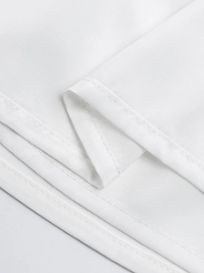Detail der Doppel-Nadel-Saumnaht und feine Textur auf einem weißen quadratischen Kleid
