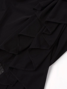 Gros plan sur la robe en tulle noir montrant les volants superposés et la texture