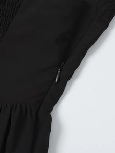 Detail view of the hidden side zipper and ruched texture on this black halter dress