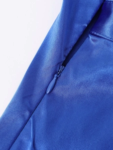 Macro shot of invisible zipper and royal blue satin fabric texture on summer dress