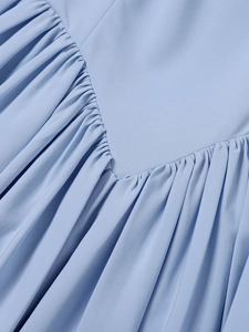 Detail of V-shaped yoke and dense gathering on a sky blue vacation halter dress