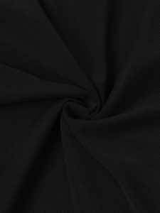 Gros plan sur un tissu en maille noire avec texture nid d'abeille et drapé souple pour robe