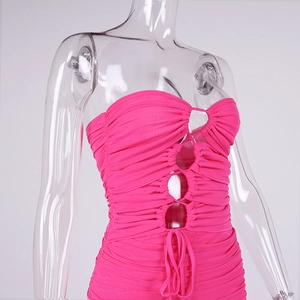 Detail of hot pink bodycon dress featuring mesh cut-outs and ruched fabric texture