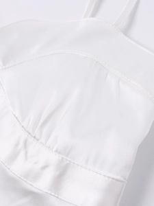 Close-up of white satin dress fabric showing delicate stitching and silky texture