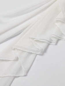 Détail macro du tissu en résille blanc avec bords à volants et coutures texturées