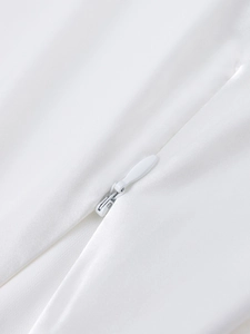 Detail of white invisible zipper on back of minimalist satin A-line cocktail dress