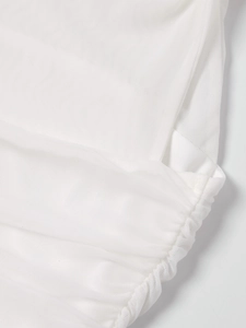 Détail macro du tissu en maille blanche avec texture froncée et bords plissés doux