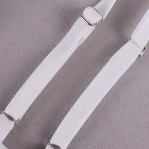 Détail de bretelles en satin blanc avec curseurs en métal argenté et coutures de précision