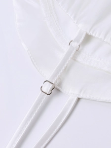 Detailed close-up of adjustable white satin straps with silver metal buckles on a dress