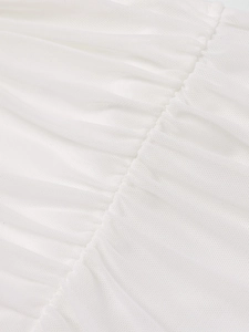 Détail du tissu en maille blanche avec fronces raffinées et coutures de qualité supérieure