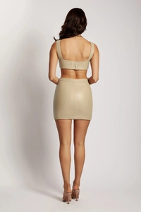 Rear view of a beige PU leather set featuring a cropped camisole and bodycon mini skirt