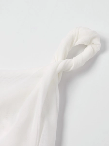 Détail macro de la bretelle en mesh blanc et du nœud délicat sur une robe d'été ajustée