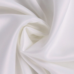 Gros plan sur un tissu en satin blanc avec drapé en spirale et texture soyeuse