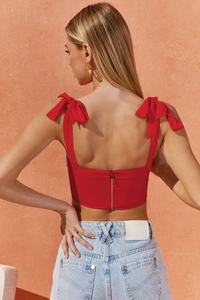 Detail of red crop top with ribbon bow on shoulder and back zipper closure