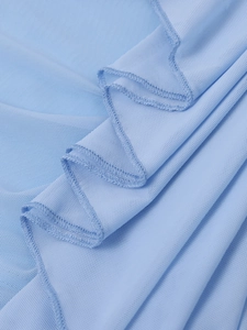 Vue détaillée du tissu en maille bleu clair avec volants délicats et coutures précises