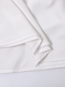 Detailed macro shot showing clean double stitching on a white halter midi dress
