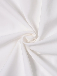 Macro shot of white halter dress fabric showing fine texture and premium cotton blend