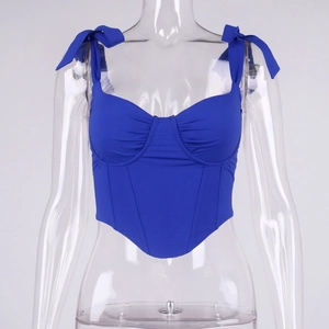 Detail of royal blue corset top with lace-up ribbon straps and structured boning