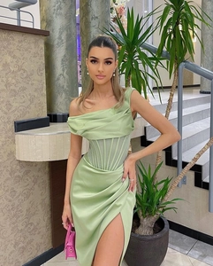Détail de la robe en satin vert sauge à une épaule avec corsage plissé et taille à baleines