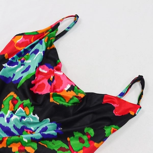 Detail of vibrant floral print fabric with thin shoulder straps on a satin summer dress