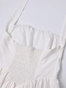 Detail of white dress featuring smocked elastic back and invisible side zipper closure