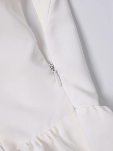Detail of hidden white zipper closure and textured fabric on the halter backless dress
