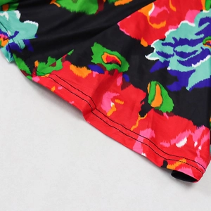 Detail of vibrant floral print and neat double-needle hem stitching on backless maxi dress