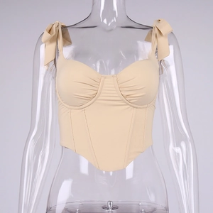 Detail view of apricot corset top featuring gathered cups and bow shoulder straps