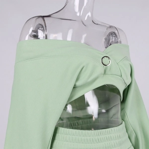 Detail of light green off-shoulder top with criss-cross front and silver ring accent