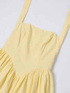 Close-up of the light yellow dress featuring a square neck and pleated V-shaped waistline