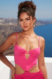 Dettaglio del top a corsetto rosa con spalline a catena in metallo e orlo cut-out