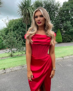 Détail d'une robe en satin rouge avec corset baleiné et fente latérale élégante pour soirée